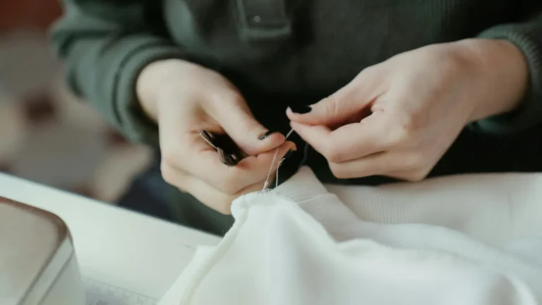 Mains de couturière qui reprise