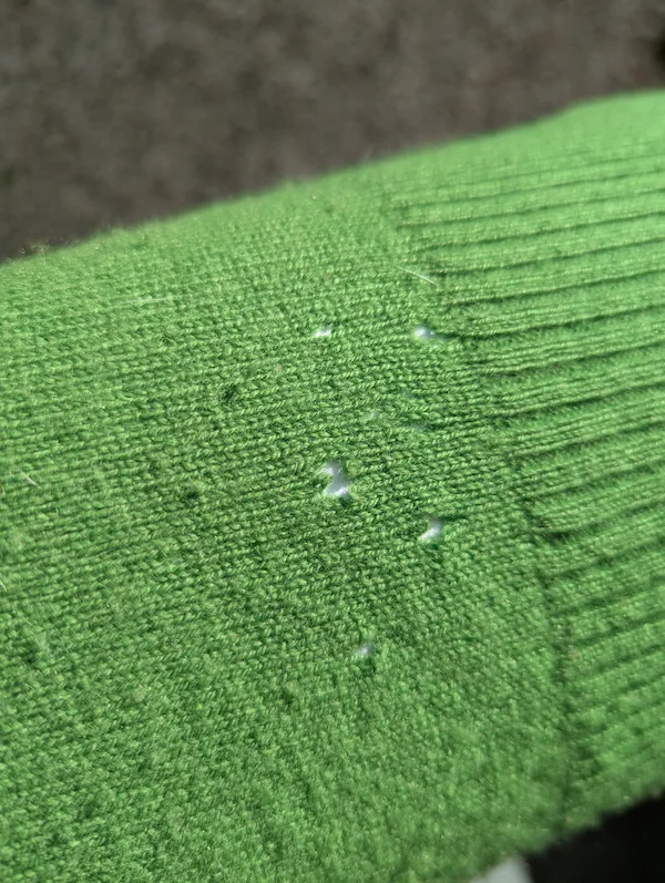 exemple petits trous d'usure dans pull vert